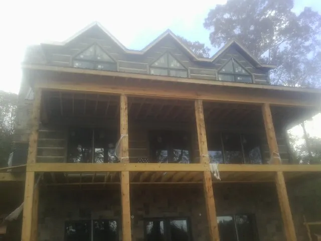 Dormers and porch framing on a large log home under construction — Roof Coating work by our crew in Collinston
